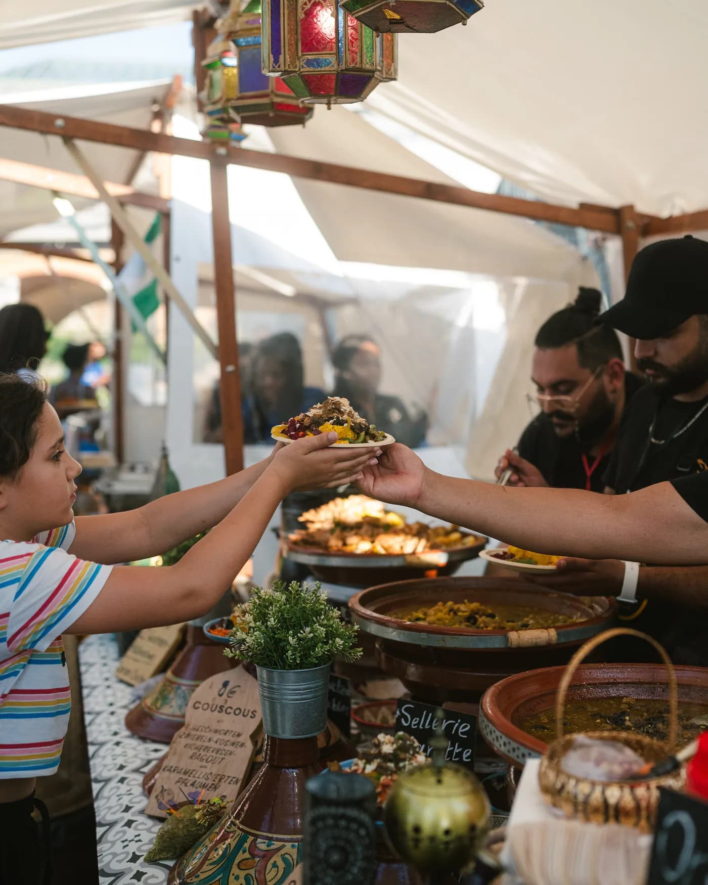 Der BAB-Stand auf einem Streetfood-Festival: marokkanische Laternen und ein Koch, der einen Teller anrichtet