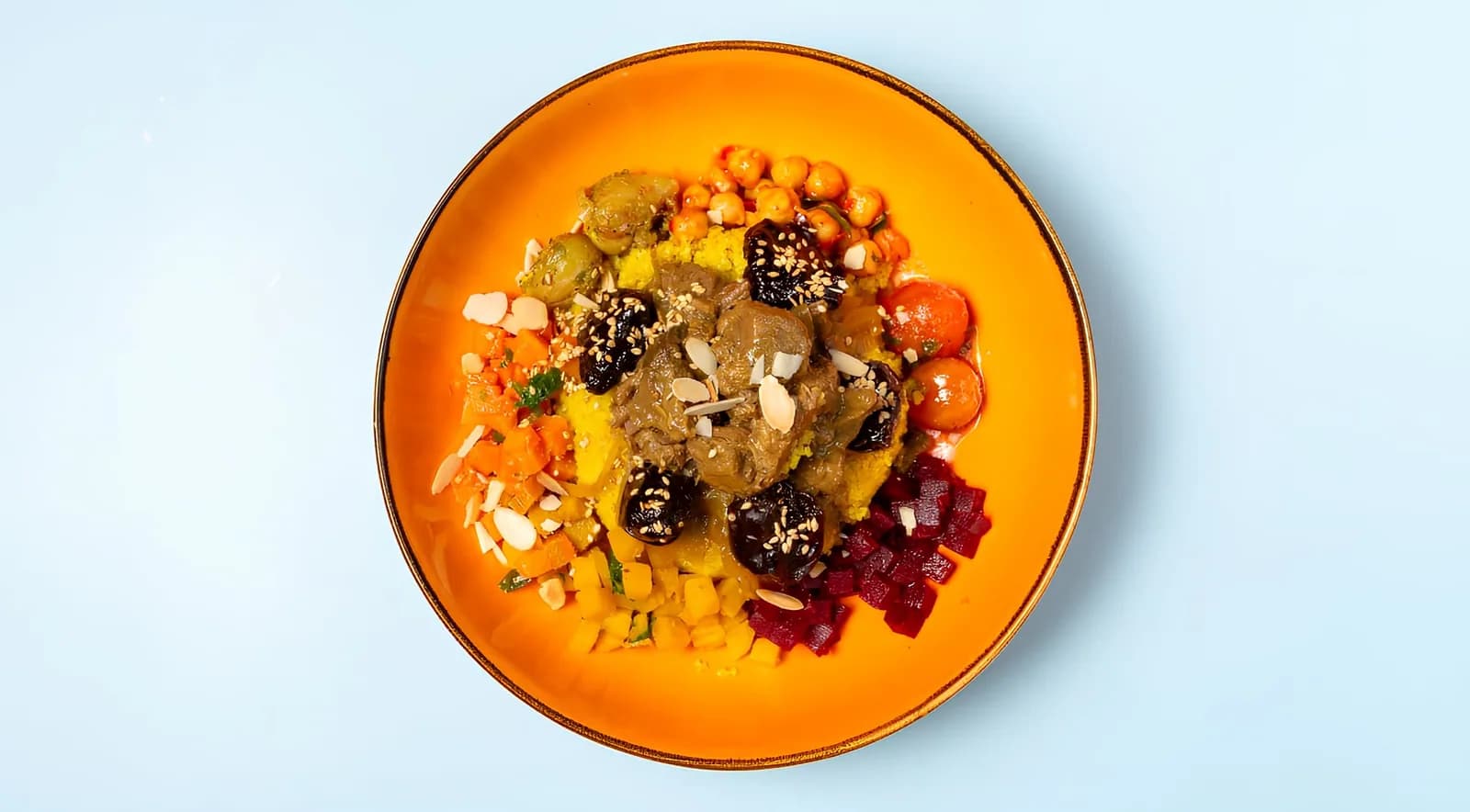Tausendundeine Nacht Bowl von oben: geschmortes Rindfleisch, Kichererbsen und Mandeln auf einem orangefarbenen Teller