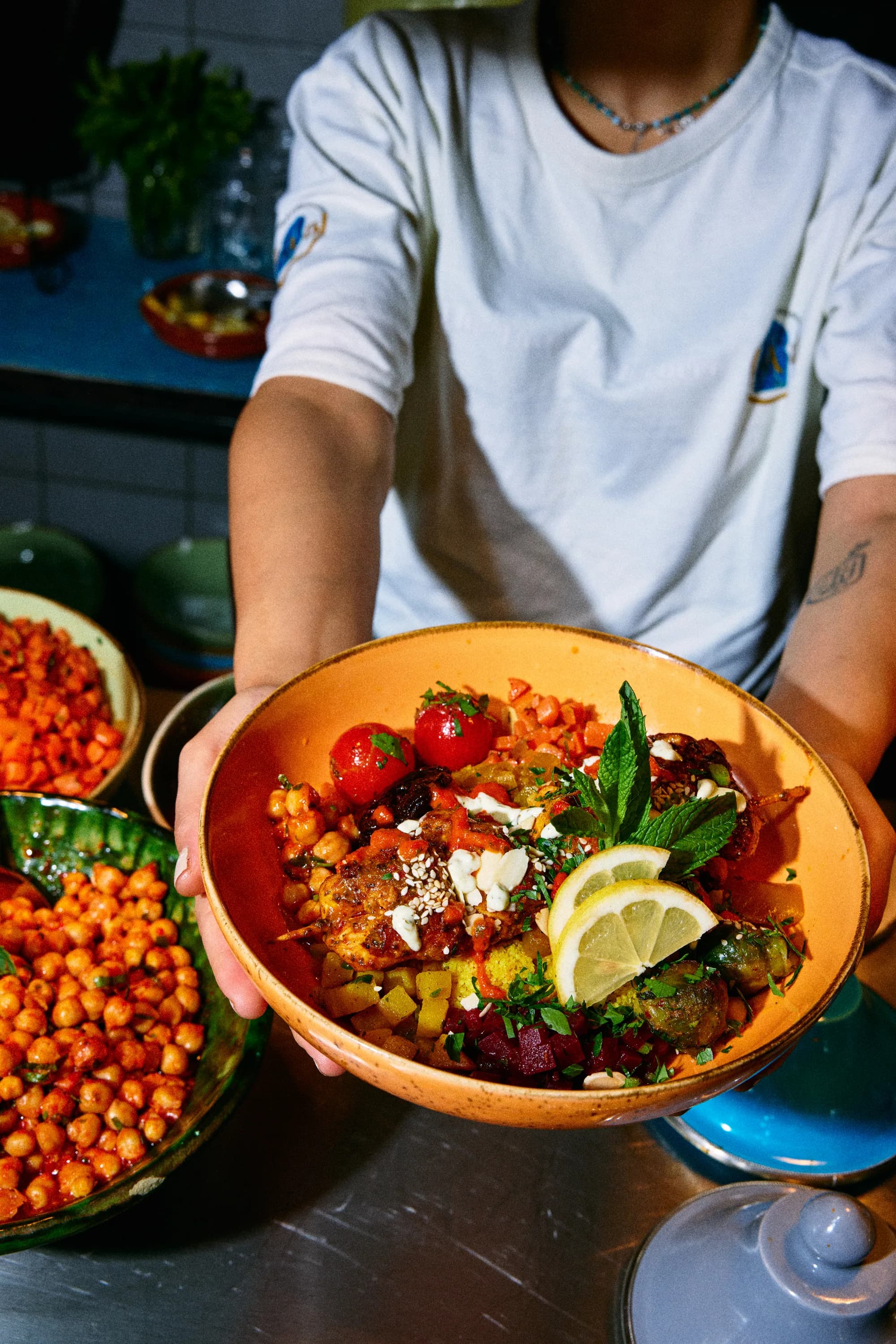 Eine Person hält eine gefüllte Couscous-Bowl in die Kamera